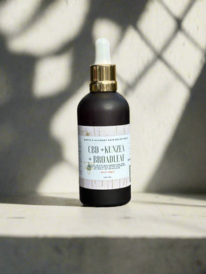 CBD + Kenzai Broadleaf bottle on a light surface with a shadowy background